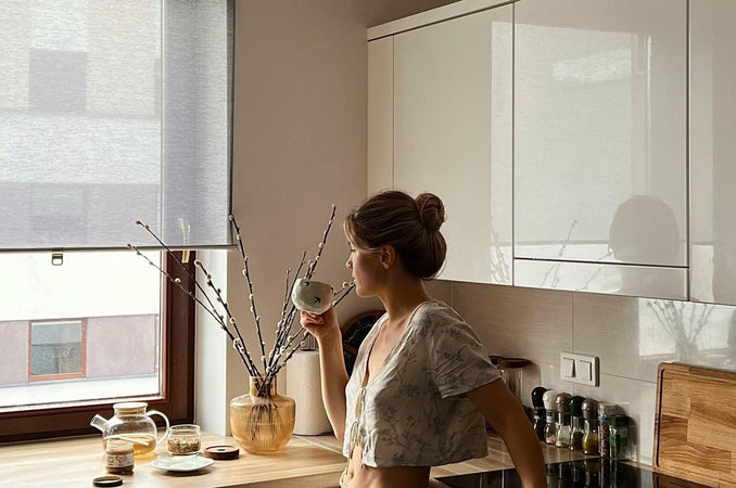 woman holding a cup and starring out the window