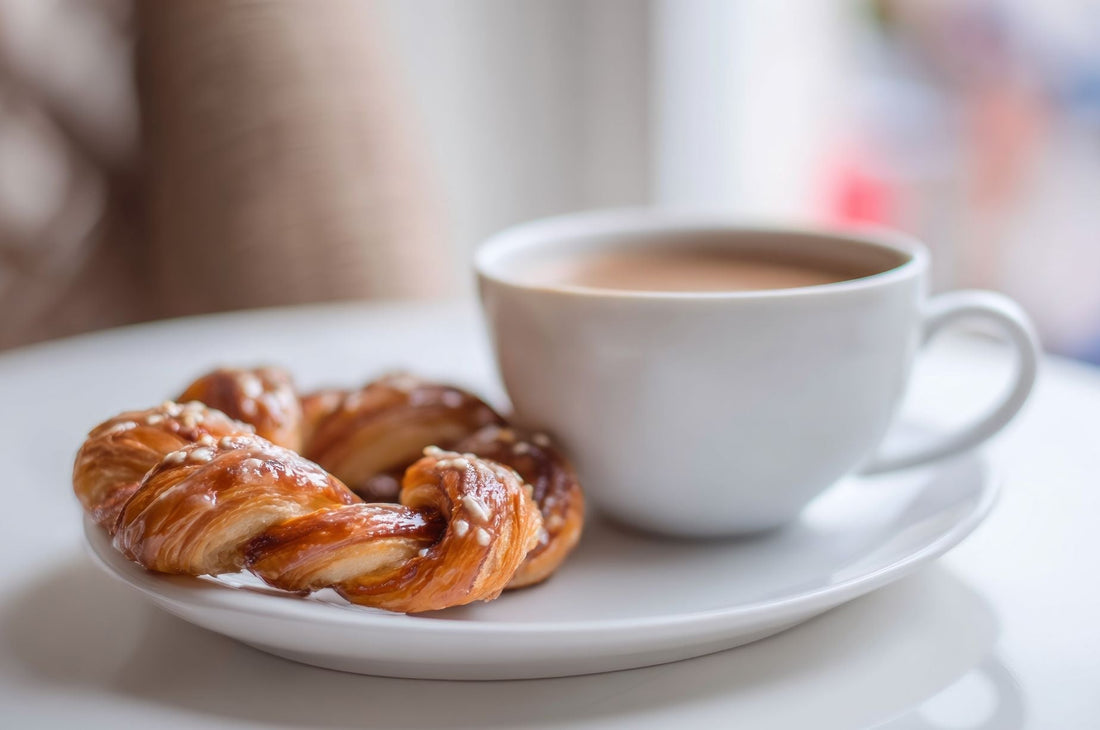 cup of coffee on plate with a pastry