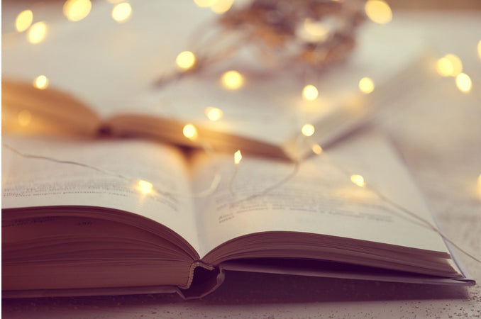 pen book with warm fairy lights softly glowing in the background.