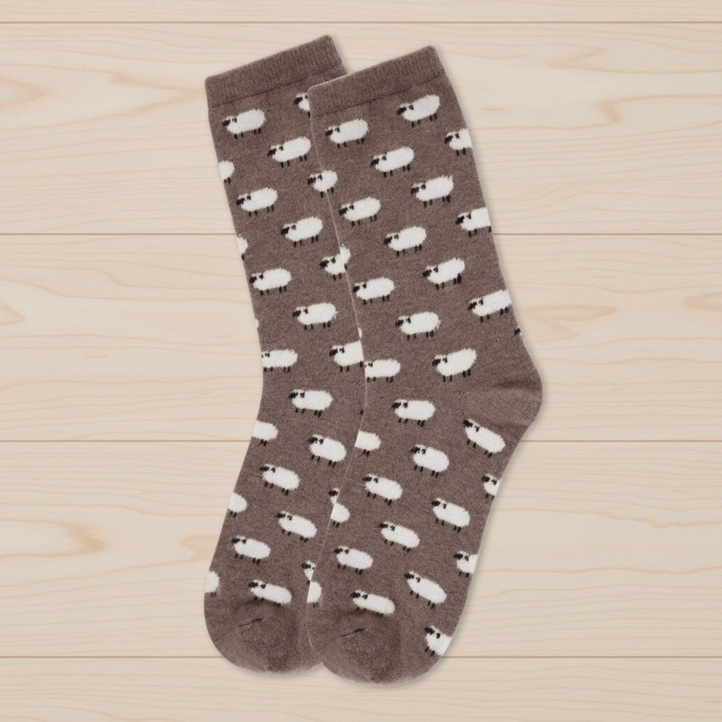 Pair of socks with sheep pattern on a wooden surface