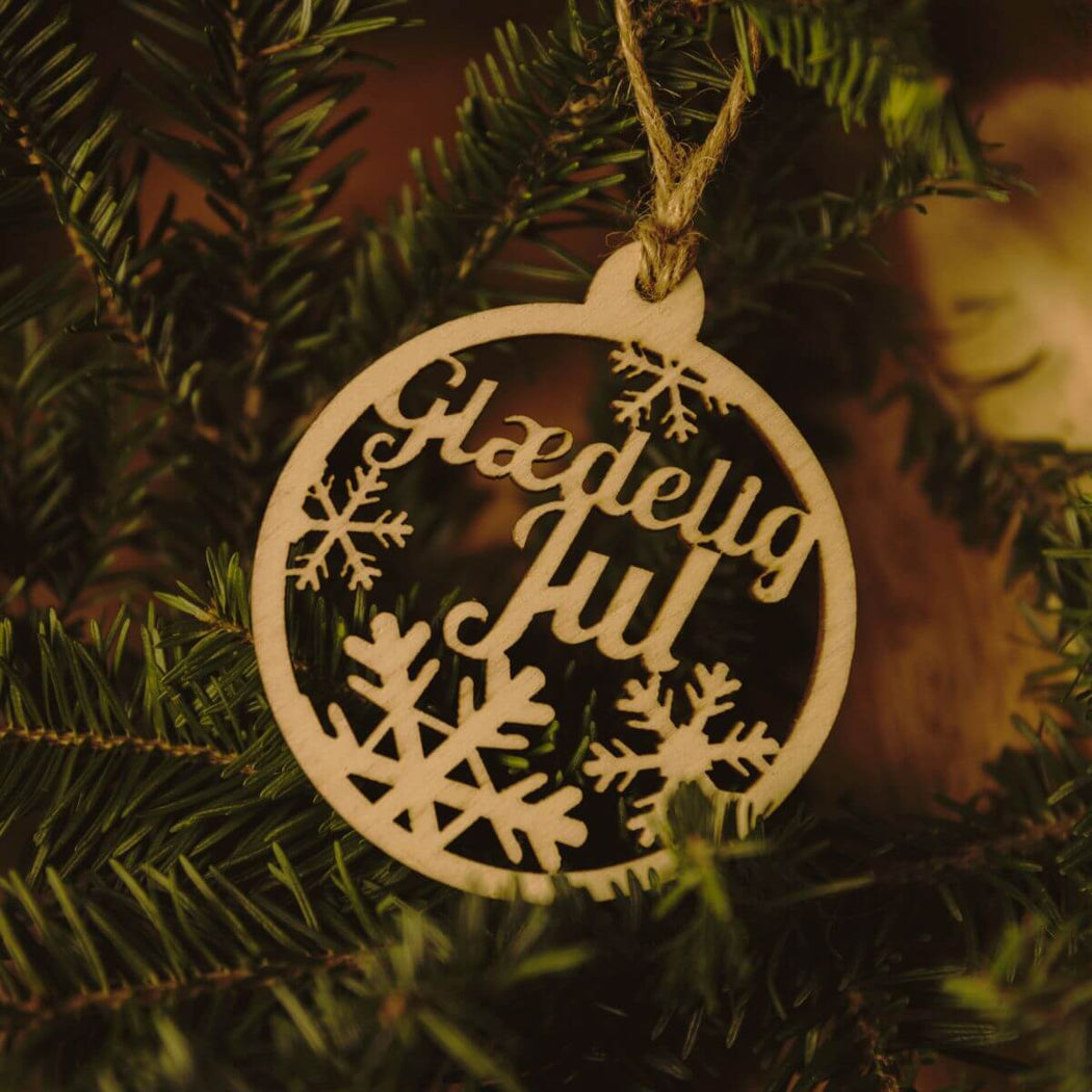 Decorative Christmas wooden ornament with 'Glaedelig Jul' text.