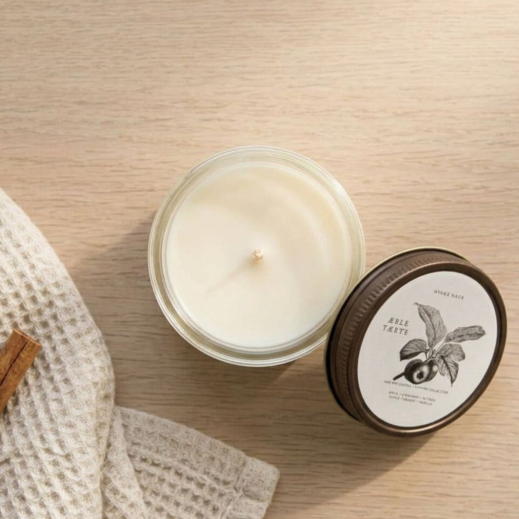 Apple Pie Soy Candle in 4 oz glass jar with lid, styled on wood table with waffle towel.