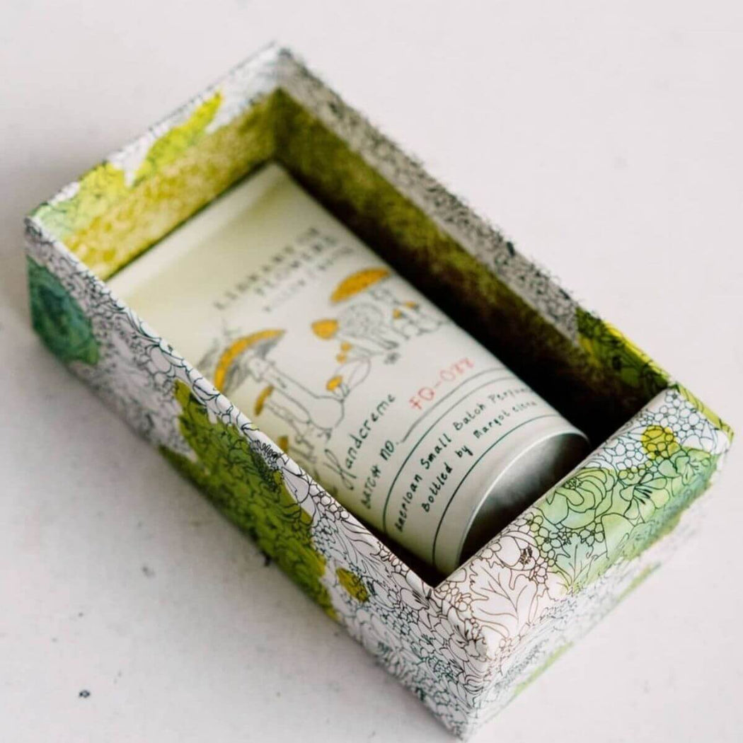 Hand cream tube in a decorative box with green and white design