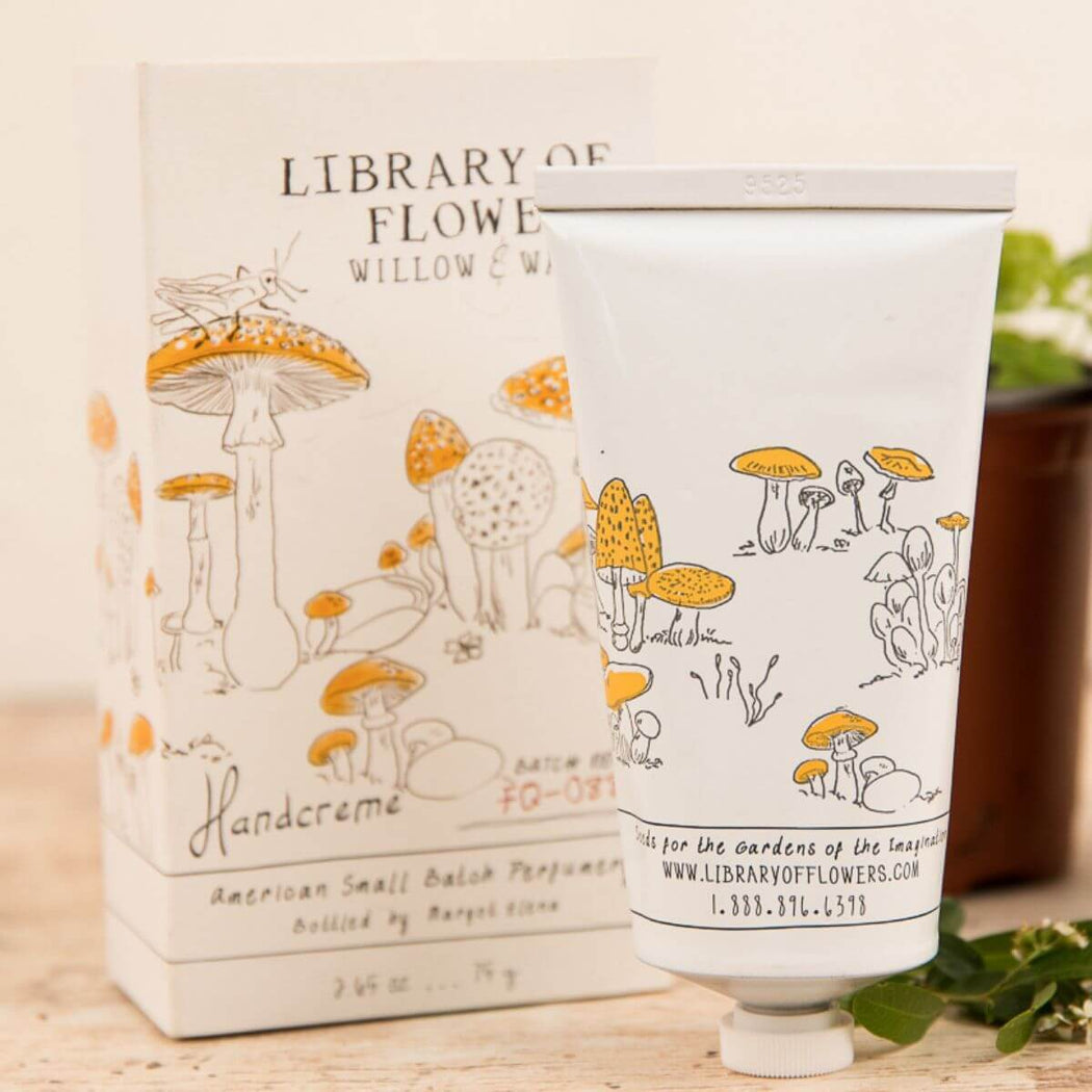 Hand cream and packaging with mushroom design on a wooden surface