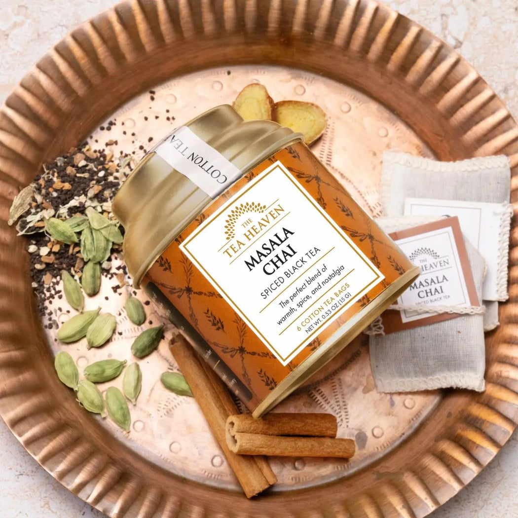 Tea packaging labeled 'Masala Chai' with tea leaves, cinnamon sticks, and cardamom on a decorative plate.