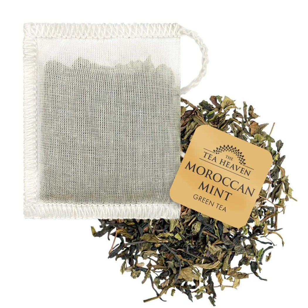 Tea bag with 'The Tea Heaven' label and loose tea leaves on a white background