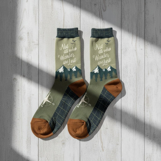 Pair of green socks with brown toes and soles on a wooden surface