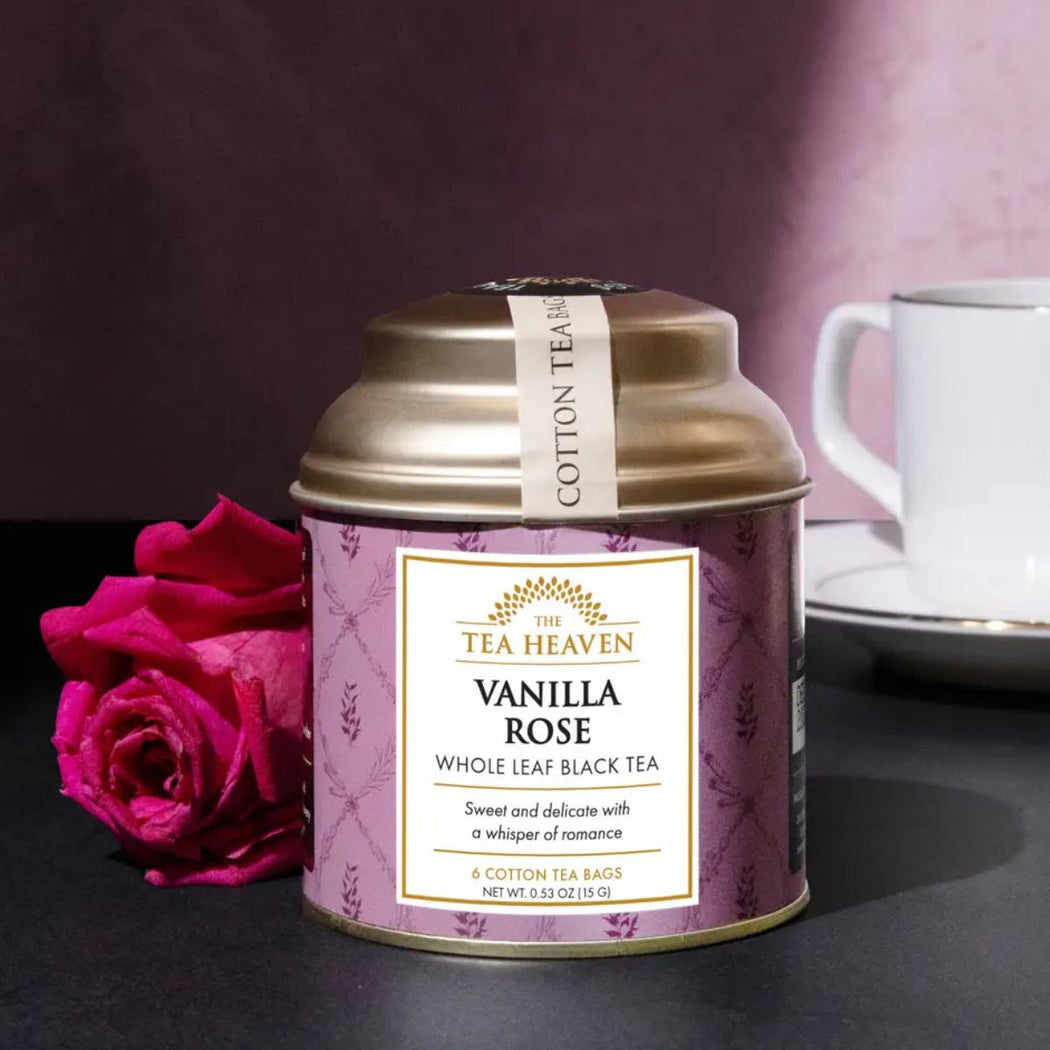 Tea canister labeled 'Vanilla Rose' from 'The Tea Heaven' with a pink rose and a cup in the background.