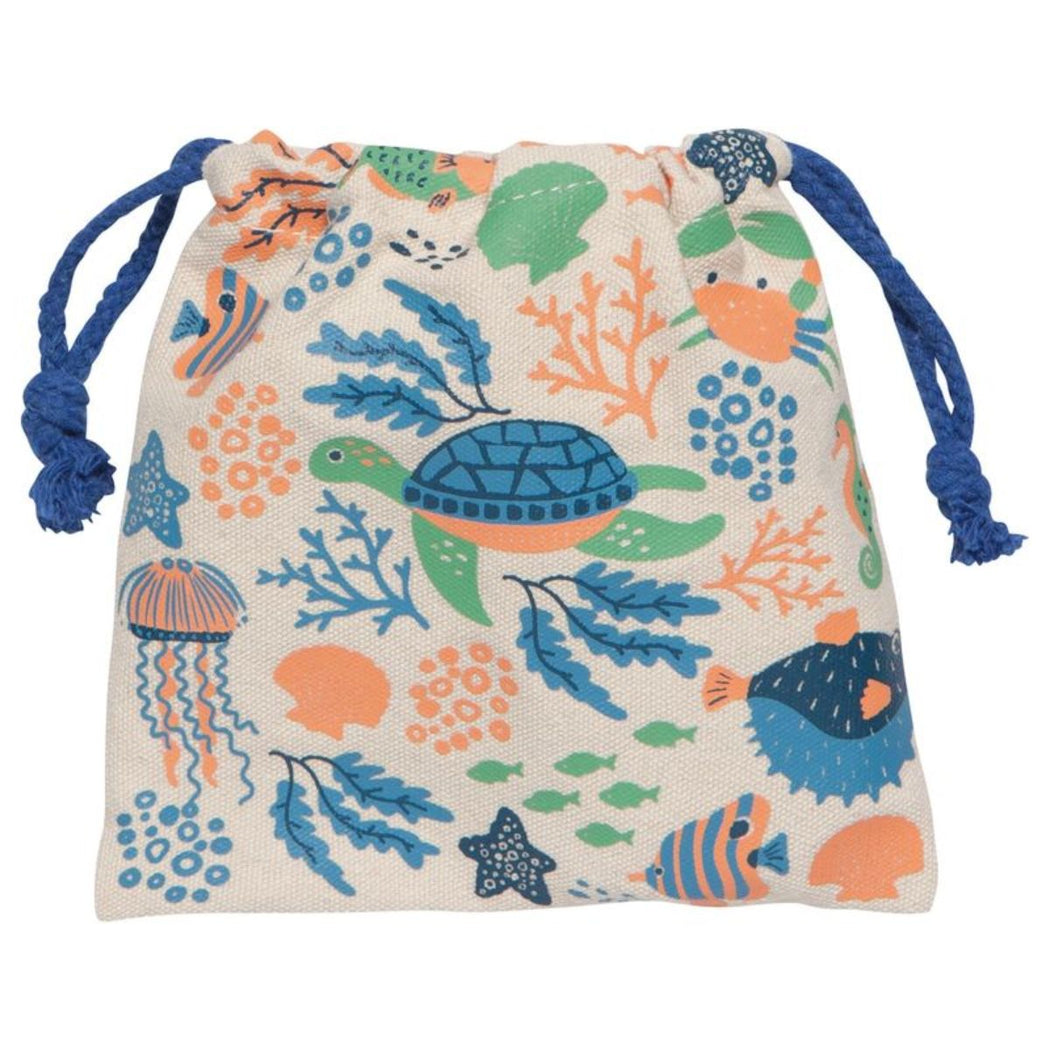 A drawstring pouch bag with an all-over ocean-themed print featuring a sea turtle, jellyfish, starfish, coral, and fish in blue, green, and orange on a cream background, with blue drawstring ties.