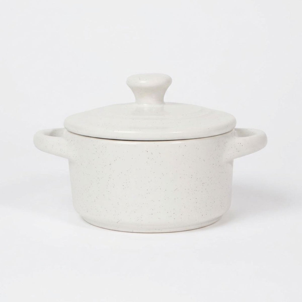 White speckled ceramic cocotte with lid on a white background